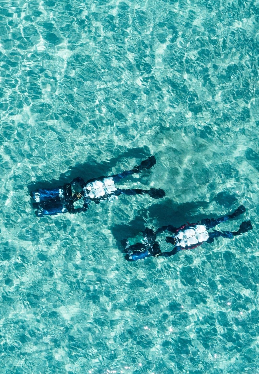 Vista dall’alto di due subacquei in superficie su acqua turchese